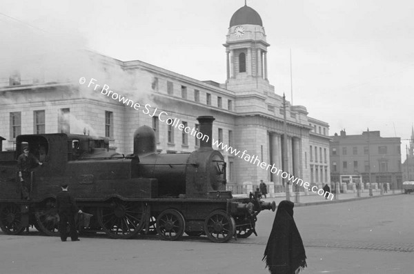 SCENE IN TOWN TRAIN IN FRONT OF CITY HALL